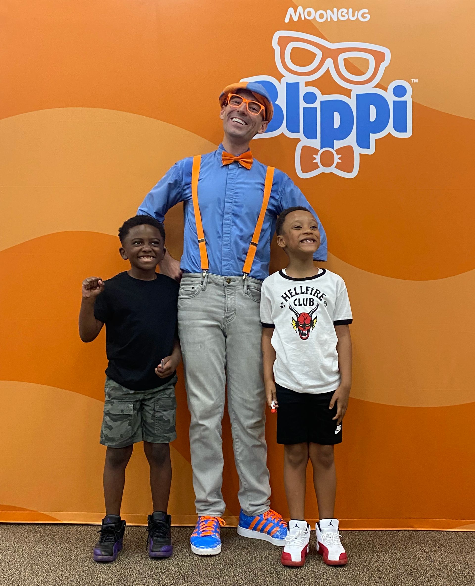 2 kids getting their photo taken with Blippi.